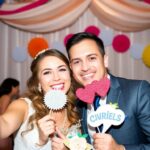 Couple souriant dans une cabine photo de mariage.