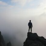 Maitre praticien PNL : jusqu’où aller dans la maîtrise du changement ? Praticien PNL contemplant un paysage vaste et brumeux.